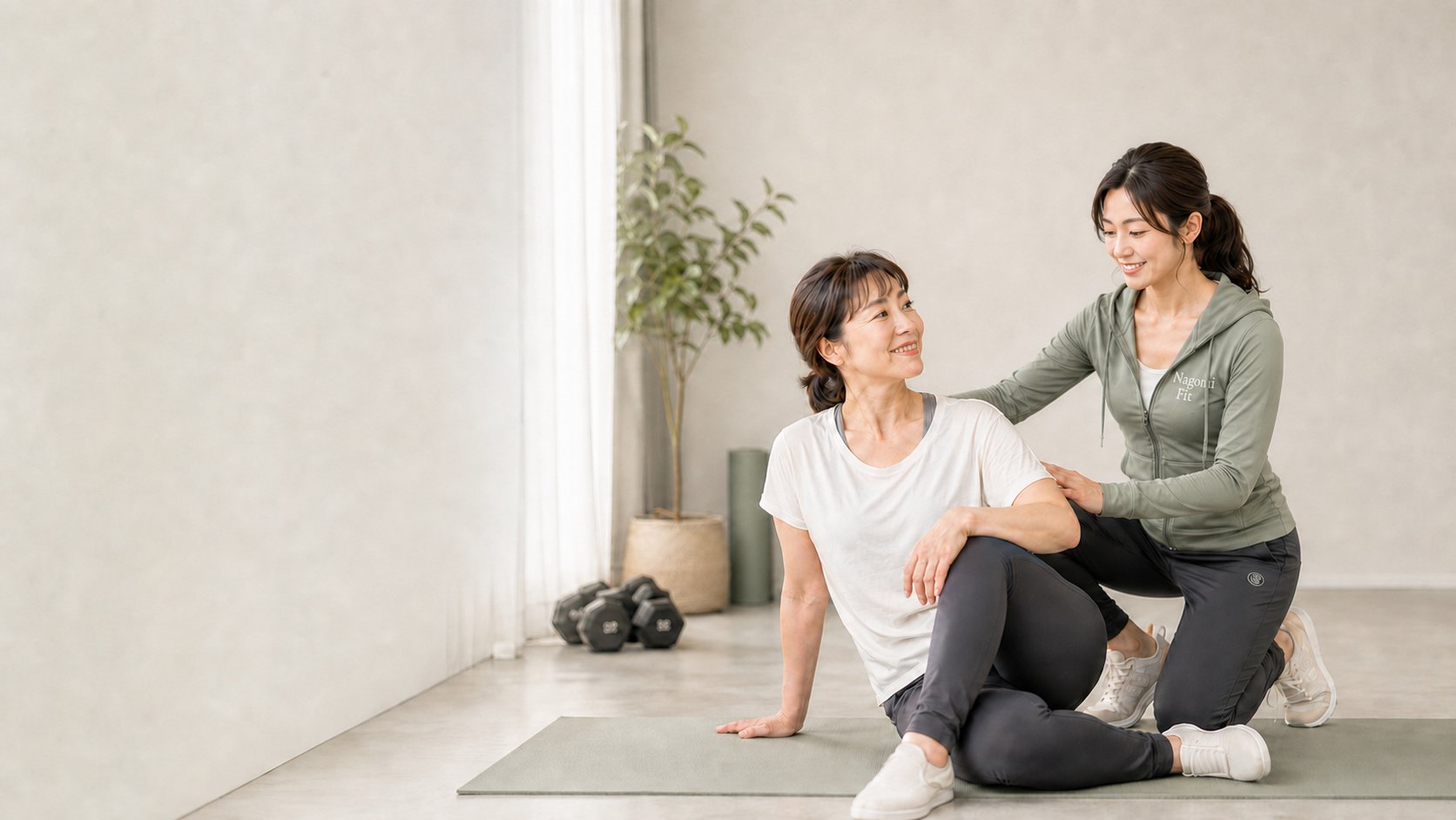 自然光の入る完全個室で、女性トレーナーが利用者に寄り添いながら指導する様子